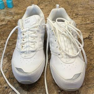 White Nike Tennis shoes. Silver toe and writing.